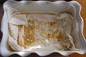 Layering phyllo sheets and nut mixture